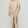 boohooMAN Tall Oversized Zip Thru Graphic Spray Wash Hooded Relaxed Flare Tracksuit | Tracksuits